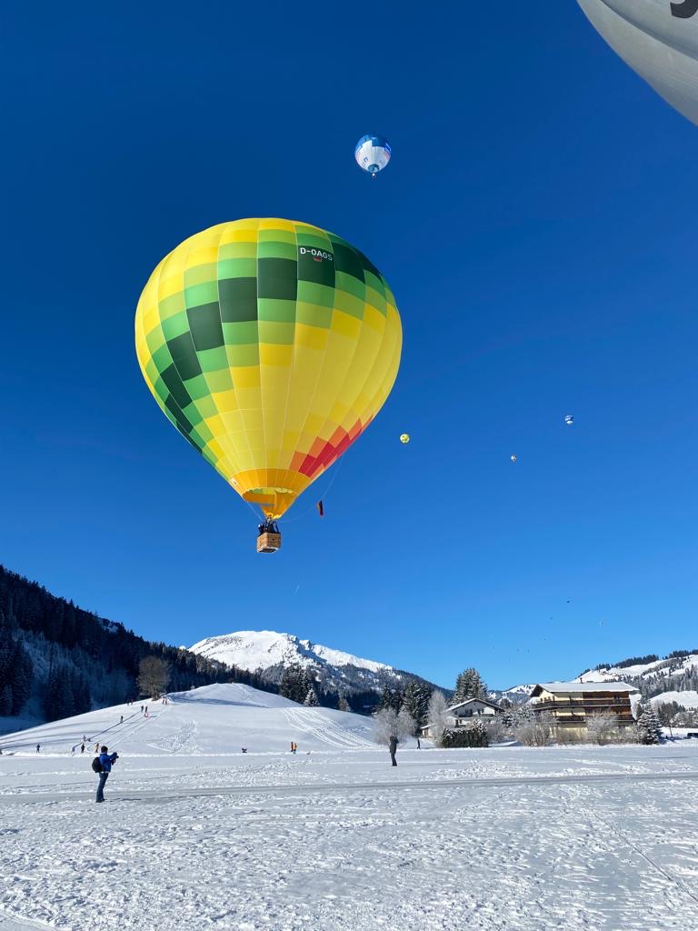 Gelber Ballon von CBT-Sports steigt in die Luft vor blauem Himmel in Tannheim