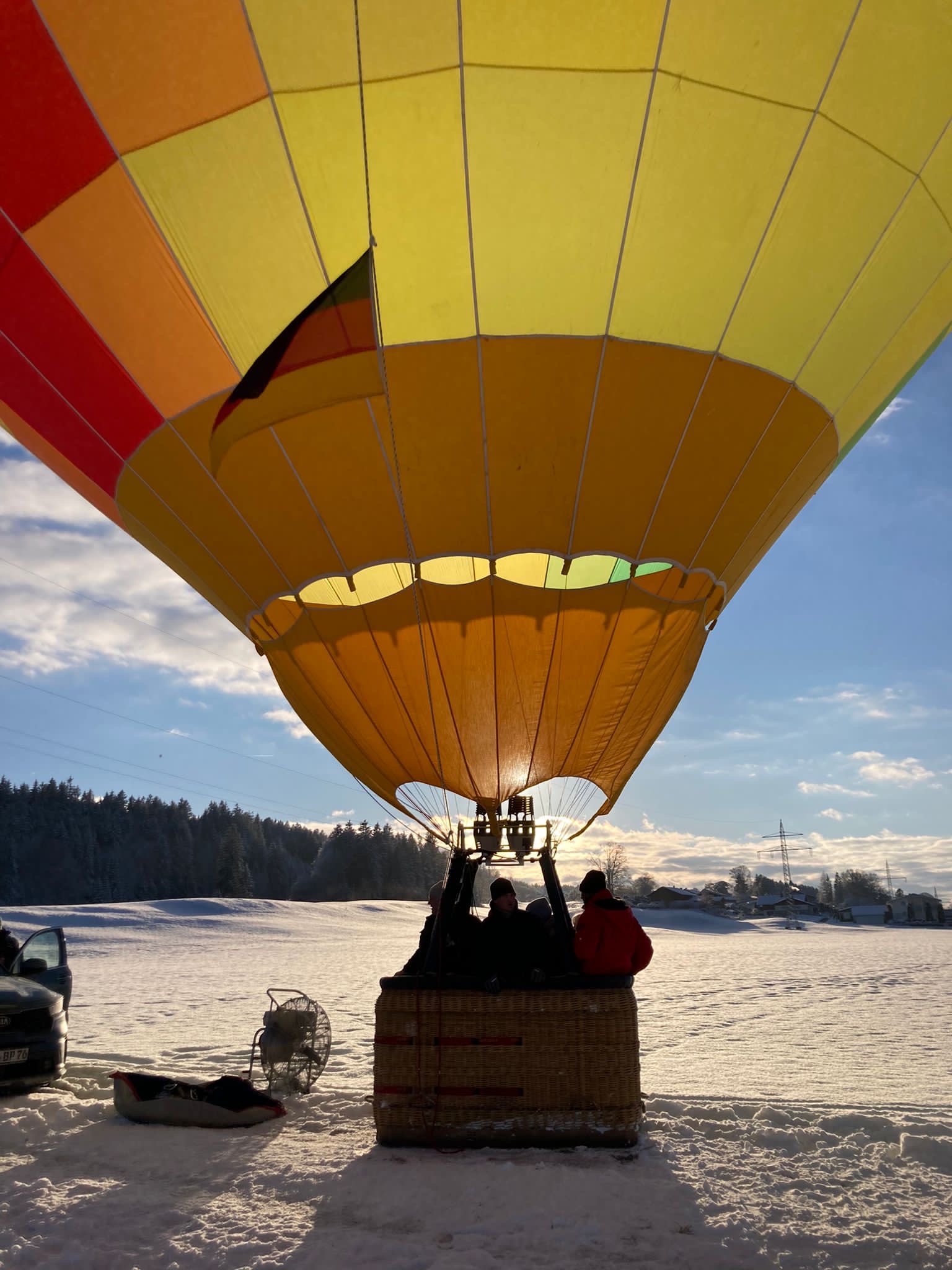 Gelber Ballon nach Ballonfahrt am Boden mit Sonne im Hintergrund